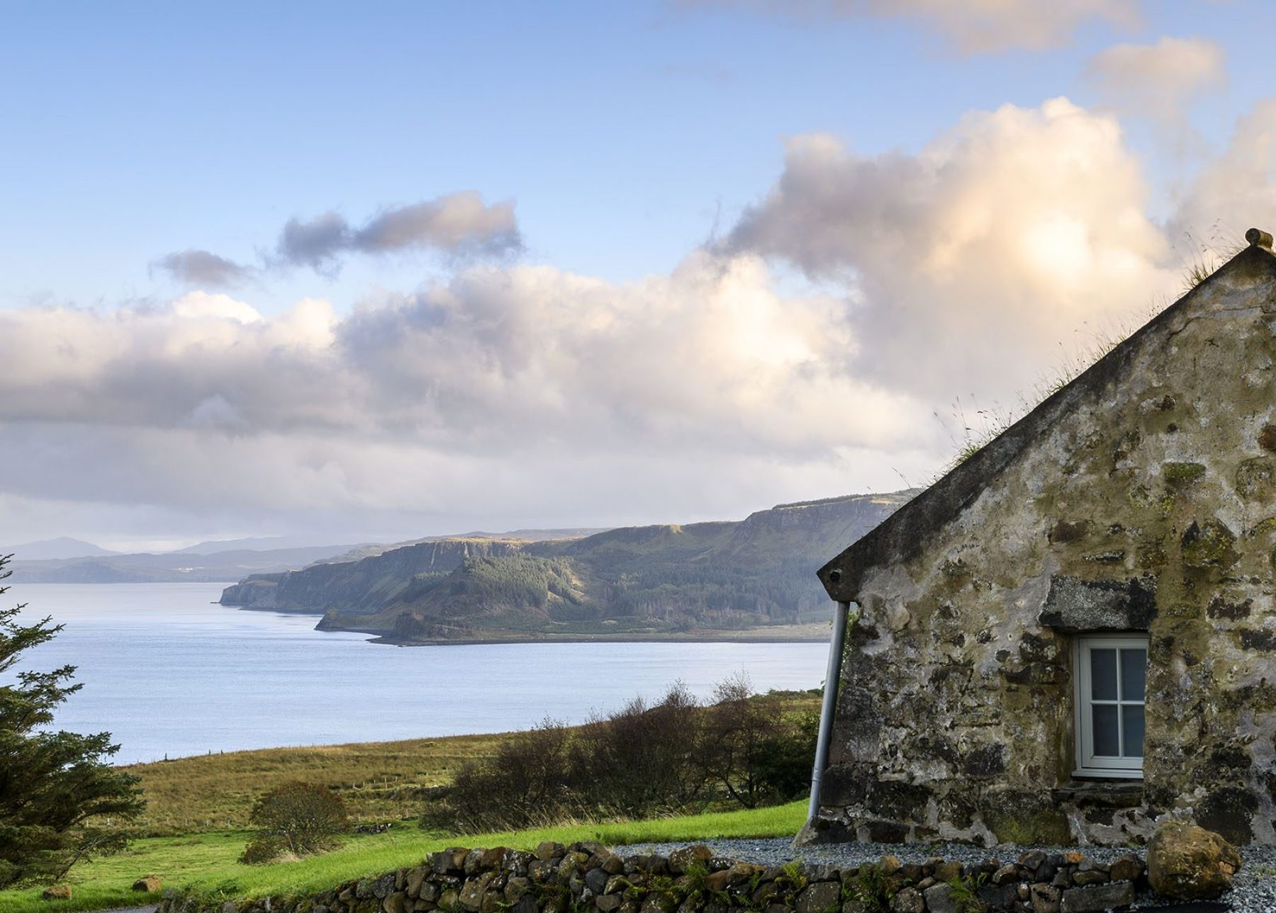 Blackhouse cottage with spectacular views to the beach at Bein an Sguirr and sea cliffs beyond.