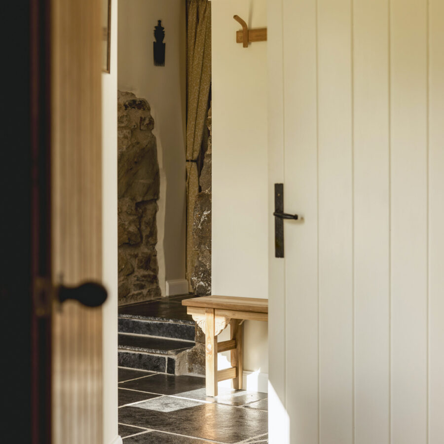 The entrance to the blackhouse cottage at Mint Croft, Skye. Panelled wooden doors and flagstone flooring.